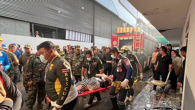 Rescue workers carry a person injured during the fire. AFP