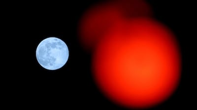 A red traffic light with the pink supermoon in the background, in High Wycombe, England. Getty Images