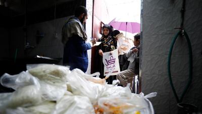 A volunteer provides free food rations to Yemeni children at a charity group in Sanaa, Yemen. EPA