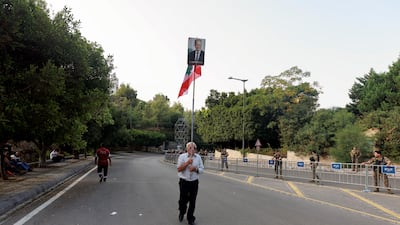An image of Lebanon's departing President Michel Aoun is held high by a supporter near the presidential palace in Baabda, Lebanon. Reuters