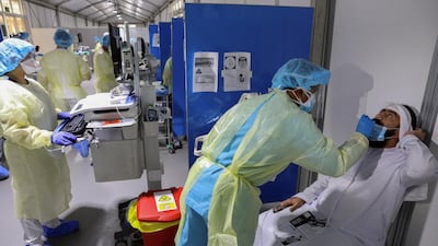 A member of medical staff swabs a man during testing at the Cleveland Clinic Abu Dhabi. Reuters