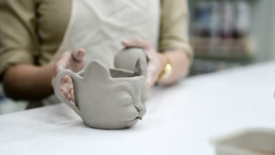A young student uses hand-building techniques to make a cup.