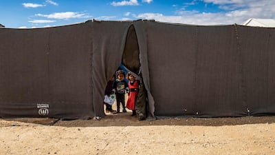 Children peek through the opening of a tent at the Kurdish-run Al Hol camp which holds suspected relatives of ISIS fighters, in the north-eastern Syrian Hassakeh governorate AFP