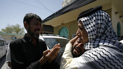 Iraqi men mourn outside a mosque in the holy city of Najaf during a funeral for victims of the ISIL-claimed lorry bombing in Baghdad's northern suburb of Sadr City on August 13, 2015. Haidar Hamdani/AFP Photo