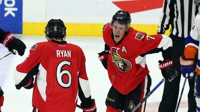 Ottawa Senators' Kyle Turris, right, reacts after being injured during third period NHL action against the New York Islanders in Ottawa, Saturday, Dec. 5, 2015. (Fred Chartrand/The Canadian Press via AP)
