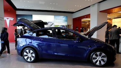 Visitors check a China-made Tesla Model Y at the EV maker's showroom in Beijing. Reuters