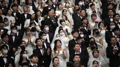 Couples wearing protective face masks attend a mass wedding ceremony organised by the Unification Church at Cheongshim Peace World Center in Gapyeong. AFP