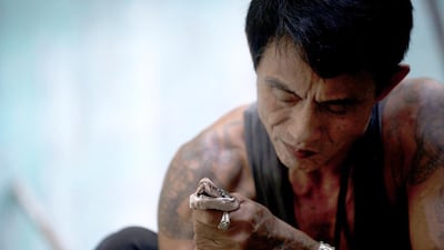 Myanmar snake charmer Sein Tin feels protected from the venomous kiss of his dancing partner by an intricate array of “magical” tattoos. Ye Aung Thu/AFP Photo