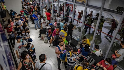 Commuters queue at a bus station a day before the government reimposes a strict lockdown in Parañaque, Metro Manila. Getty Images