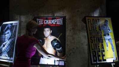 An employee handles an official signed poster of Muhammad Ali to be sold at auction during the Hedge Fund Fight Nite 2016 in Hong Kong, China. Justin Chin / Bloomberg