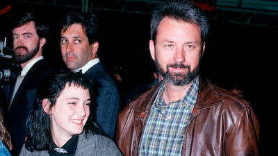 Winona Ryder, wearing a grey jacket over a black jumper and shirt, with Michael Nesmith of The Monkees at the premiere of 'Amazing Grace and Chuck' on March 26, 1987. Getty