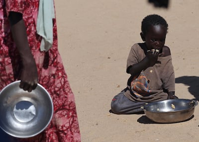 A Sudanese orphaned child refugee from El Fasher eats a meal provided by the Group Kitchen Project inside the Tine transit camp in eastern Chad. Reuters