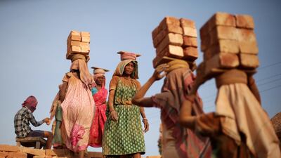 Indian labourers carry bricks on their headson a hot afternoon near Kolkata, eastern India. Piyal Adhikary / EPA