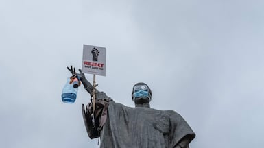 The statue of the late Kenyan minister of justice Tom Mboya is adorned with a placard reading 'Reject not Amend' ahead of a planned demonstration against a now-withdrawn tax bill in Nairobi. AFP