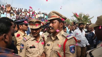 People throw flower petals on Indian policemen guarding the area where four men accused of the gang rape were shot dead, in Shadnagar some 50 kilometers from Hyderabad. AP Photo