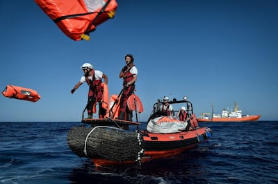 Members of humanitarian organisations SOS Mediterranee and Medecins Sans Frontieres (MSF - Doctors Without Borders) perform a rescue drill during a joint operation at the MV Aquarius, a search and rescue ship run in partnership between the SOS Mediterranee and MSF, some 24 nautical miles (50km) off Libya's coast, in the Mediterranean Sea, on May 4, 2018. Louisa Gouliamaki / AFP
