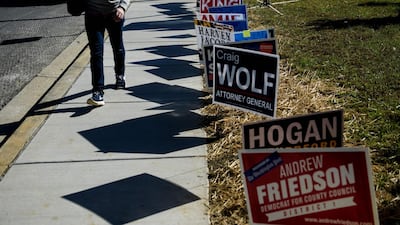 A man walks away past campaign signs after voting during early voting at a community center in Potomac, Maryland, two weeks ahead of the key US midterm polls. AFP