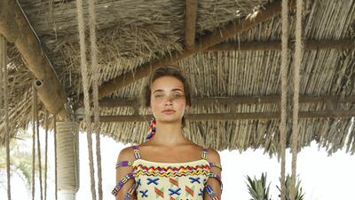 A yellow cropped top and trousers pairing is decorated with traditional zig-zag and X-shaped embroidery