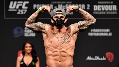 Dustin Poirier flexes while on the scale. Getty Images