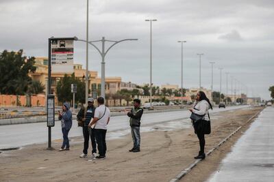 Commuters well wrapped up for the elements waiting for their bus at 16th Street in Khalifa City A in Abu Dhabi. Victor Besa / The National