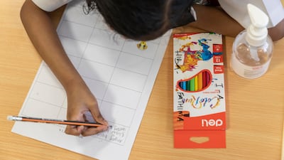 A pupil gets back into the swing of school with coloured pencils and hand sanitiser at the Delhi Private School.