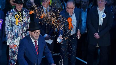 Confetti is thrown over Mr Galloway by Just Stop Oil protestors as he gives his speech after being declared winner. AP