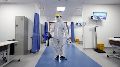 A health care worker disinfects a ward during a visit to the Mohamed bin Zayed Field Hospital - Ajman, operated by Abu Dhabi Health Services Company (Seha). Photos by Chris Whiteoak / The National