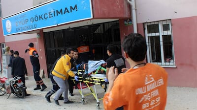 Members of emergency services evacuate an injured man on a stretcher on January 18, 2016 after mortar shells landed near a school in Kilis killing at least one person. Ilhas News Agency/AFP