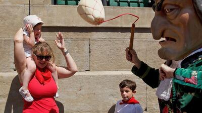A girl reacts as Caravinagre ‘Vinegar face’ kiliki hits her with his sponge during the Comparsa de Gigantes y Cabezudos, or Giants and Big Heads parade, on the third day of the San Fermin Running of the Bulls festival in Pamplona, Spain. Pablo Blazquez Dominguez / Getty Images