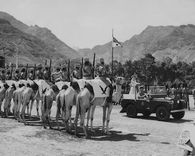 Queen Elizabeth II and Prince Philip stand together in the back of a Land Rover as they inspect a guard of Camel and Armored Units of the Aden Protectorate Levies at the Crescent Gardens in Aden, in 1954. (Photo by Central Press/Hulton Archive/Getty Images)