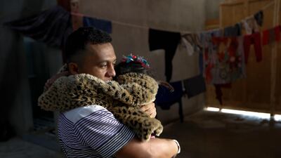 A man hugs his daughter inside a former concert venue serving as a shelter for migrants in Tijuana, Mexico. AP Photo