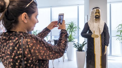 A visitor takes a photo of an life sized man made of Lego. Leslie Pableo for The National