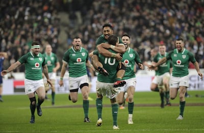 Jonathan Sexton, centre, is hugged by teammates after kicking the match-winning drop goal against France. Thomas Samson / AFP
