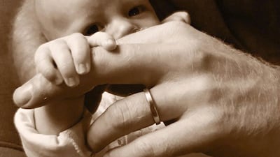 Archie as a baby, holding Prince Harry's hand. Photo: Sussex Royal