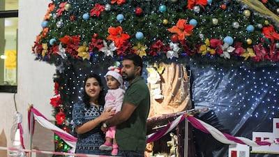A family has their picture taken outside St Paul's Catholic Church in Mussafah. Khushnum Bhandari for The National