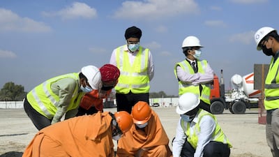 Head priests go through designs with contractors and workmen at the site of the new Hindu temple outside Abu Dhabi. Khushnum Bhandari for The National
