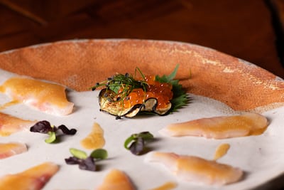 Thinly sliced seabass with yuzu, truffle oil and salmon roe. Photo: Zuma Abu Dhabi