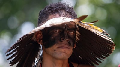 A Guarani Mbya man in traditional indigenous dress joins a protest on property being developed by the real estate company to make way for apartment buildings, next to his community's land in Sao Paulo, Brazil. AP
