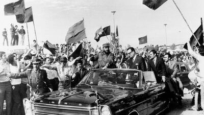 Fidel Castro rides with Chilean president Salvador Allende through a crowd waving communist flags in Santiago, Chile, on November 10, 1971. AP Photo