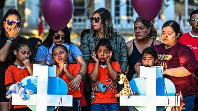 Football teammates of Tess Mata, who died in the Texas school shooting, cry as they visit a makeshift memorial outside the Uvalde County Courthouse. AFP