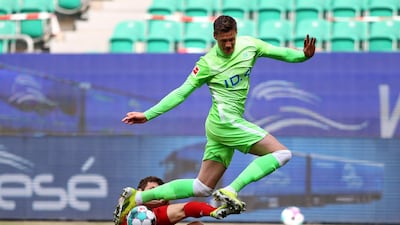 Wout Weghorst, who scored Wolfsburg's first goal, is challenged by Bayern's Benjamin Pavard. EPA