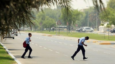 Two students from the Sheikh Khalifa bin Zayed Arab Pakistan School cross 21st Street in Abu Dhabi after school hours.
