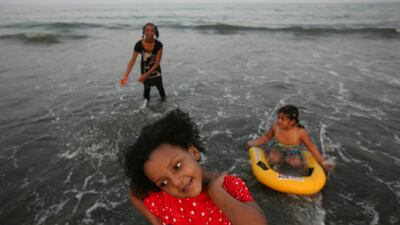 Girls play in the surf on the beach in the Faseel neighbourhood in Fujairah. Amy Leang / The National
