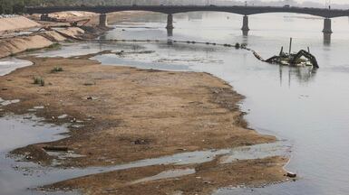 This photograph shows an excavator dredger operating along the exposed riverbed of the Tigris River in central Baghdad on October 21, 2025. The river's water level has significantly declined due to ongoing drought conditions in Iraq, reduced rainfall, and diminished water flow from upstream neighboring countries. (Photo by AHMAD AL-RUBAYE / AFP)