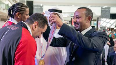 Mr Ahmed presents a medal to an athlete.