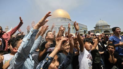 Palestinian children stand under water sprayed to cool the crowd during the last Friday prayer of Ramadan near the Dome of the Rock in the Al Aqsa Mosque compound in Jerusalem's Old City. AP Photo