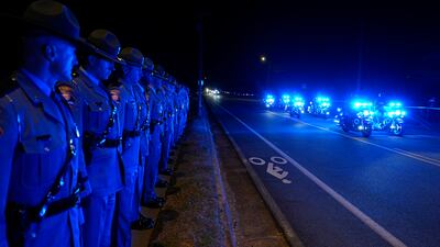 Police in Plains, Georgia, line the side of a road as the hearse carrying former US president Jimmy Carter passes by. EPA