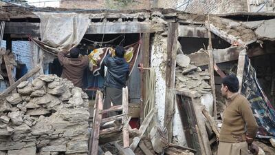 People survey a damaged house in Swat valley. Haseeb Ali / EPA