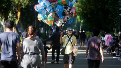 A vendor wears a face mask as he sells balloons near the Bogor Palace in Bogor, Indonesia. The Indonesian government has imposed a new set of regulations known as 'new normal', which will be implemented in stages, starting in early June for some provinces. EPA