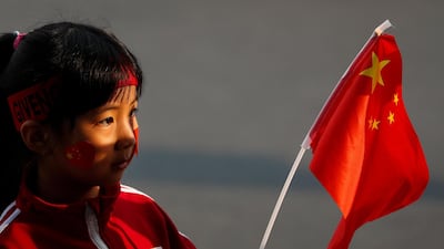 A child waves a national flag in Beijing. AP